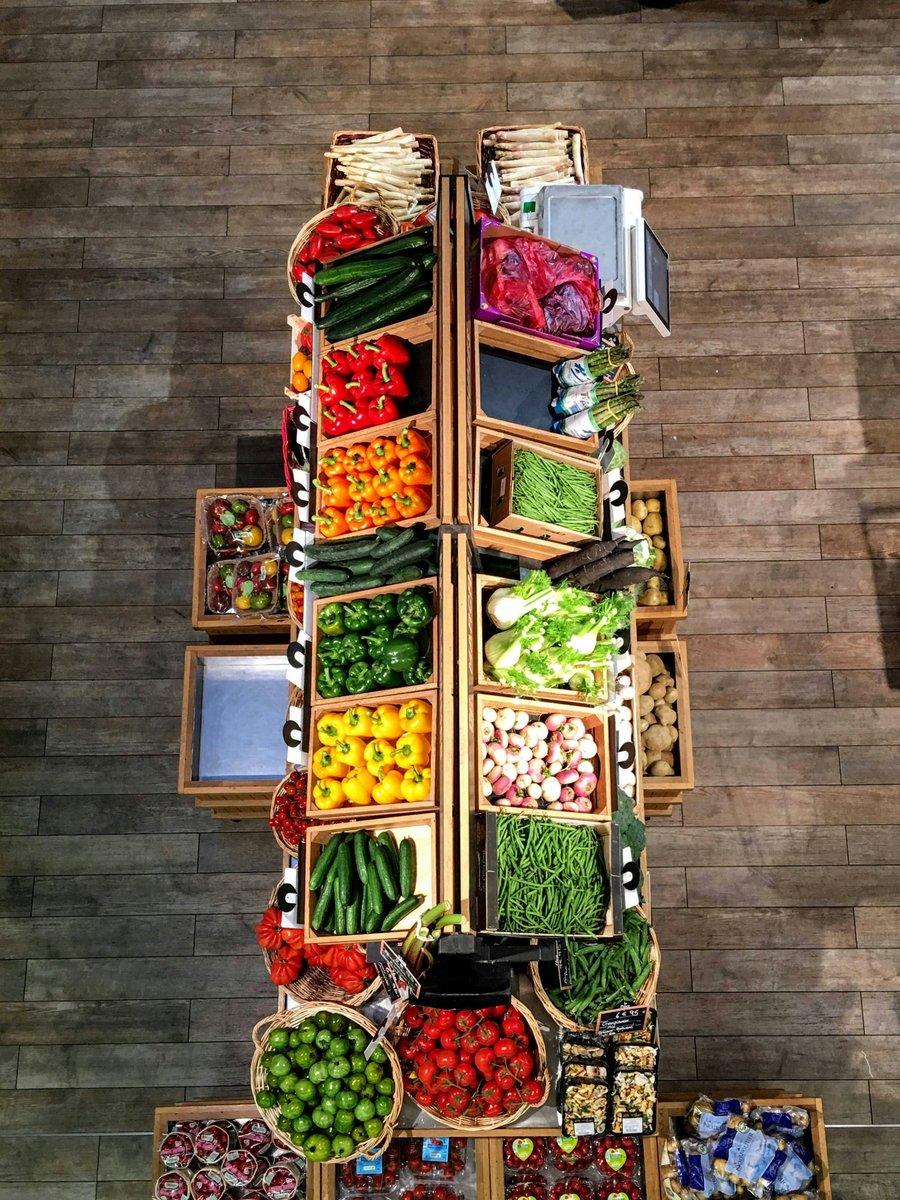 Étal de marché vu du dessus avec des cagettes de légumes de saison