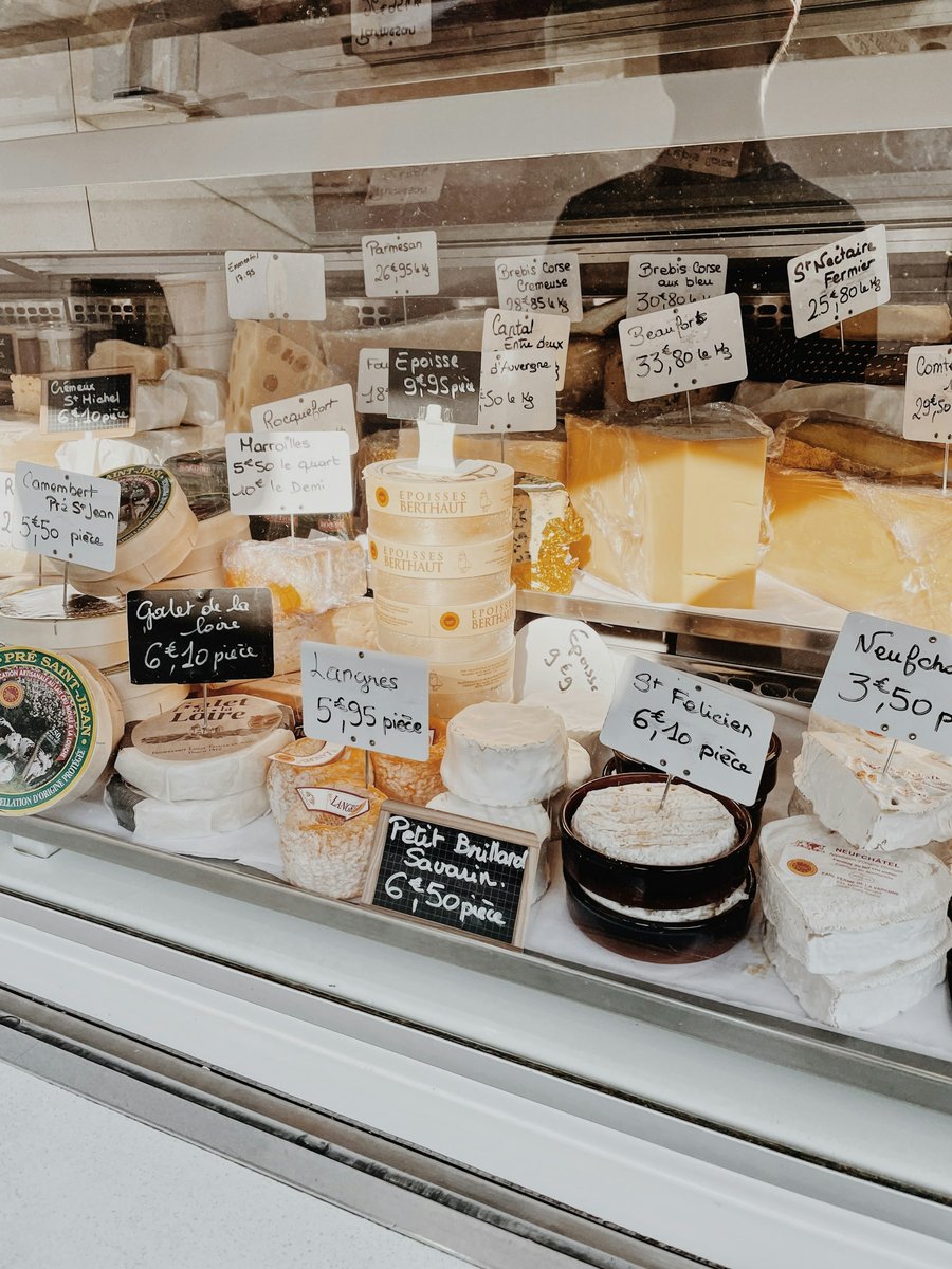 Vitrine d'un fromager : fromages à pâte molle et à croûte fleurie avec leurs étiquettes de prix